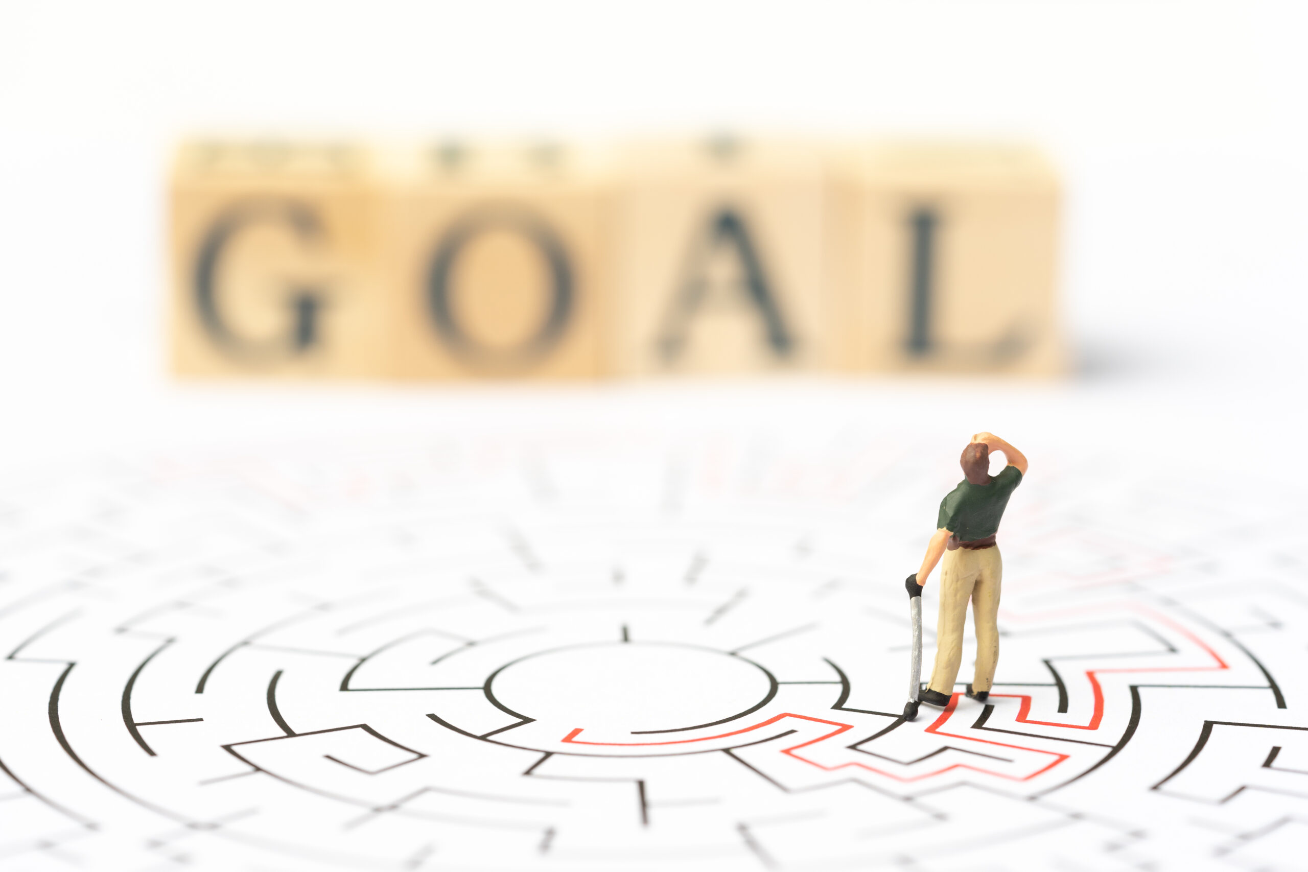 Miniature people, golf player in the labyrinth or maze figuring