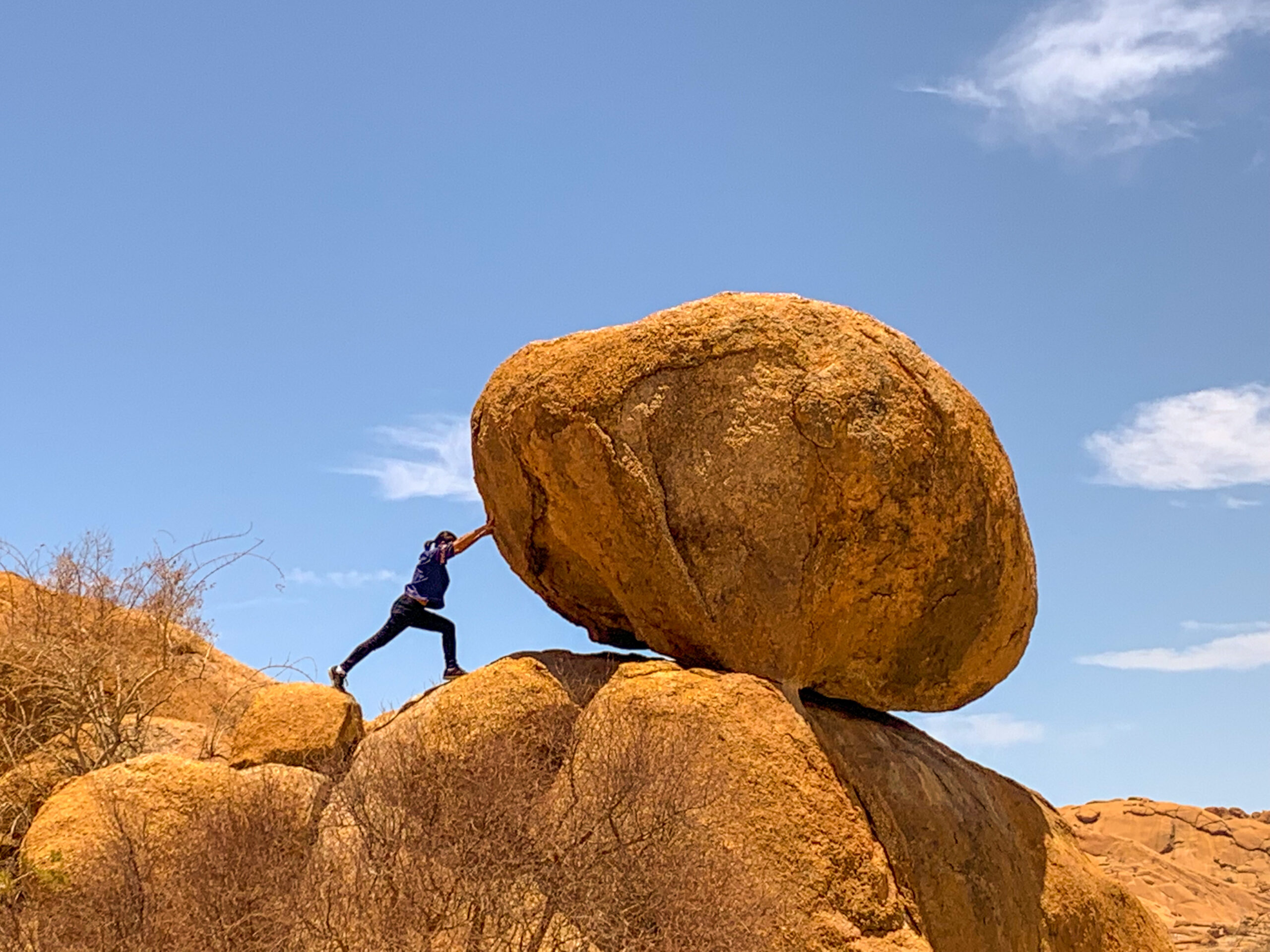 rear-view-man-standing-rock-formations-against-clear-sky